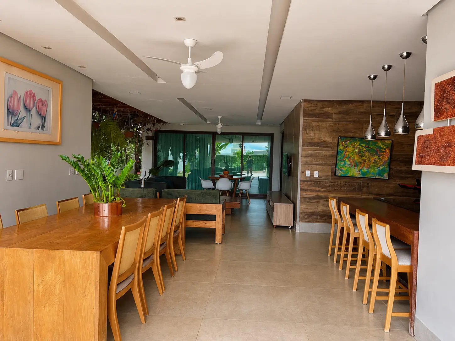 Varanda gourmet com mesa em madeira maciça, bancada e forro trabalhado