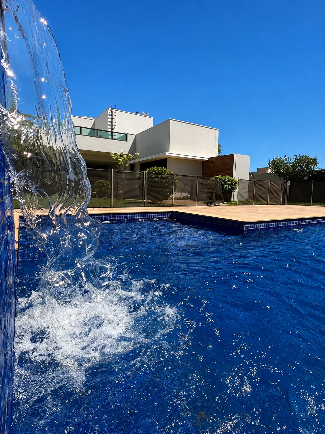 Piscina com cascata e deck de madeira